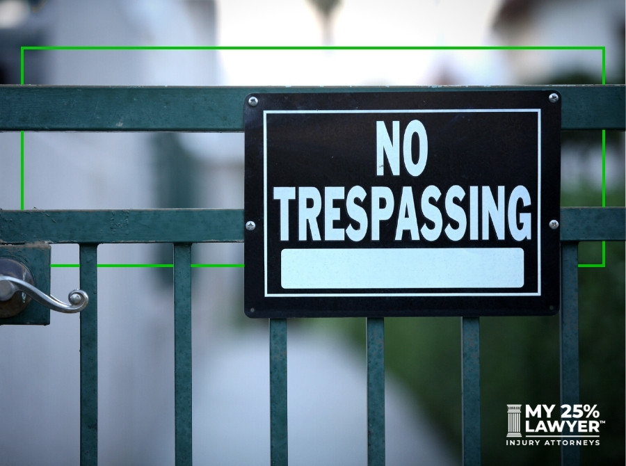 No trespassing sign on green fence