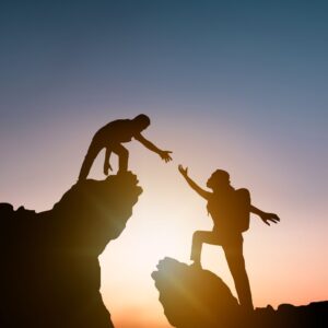 person helping someone over a ledge