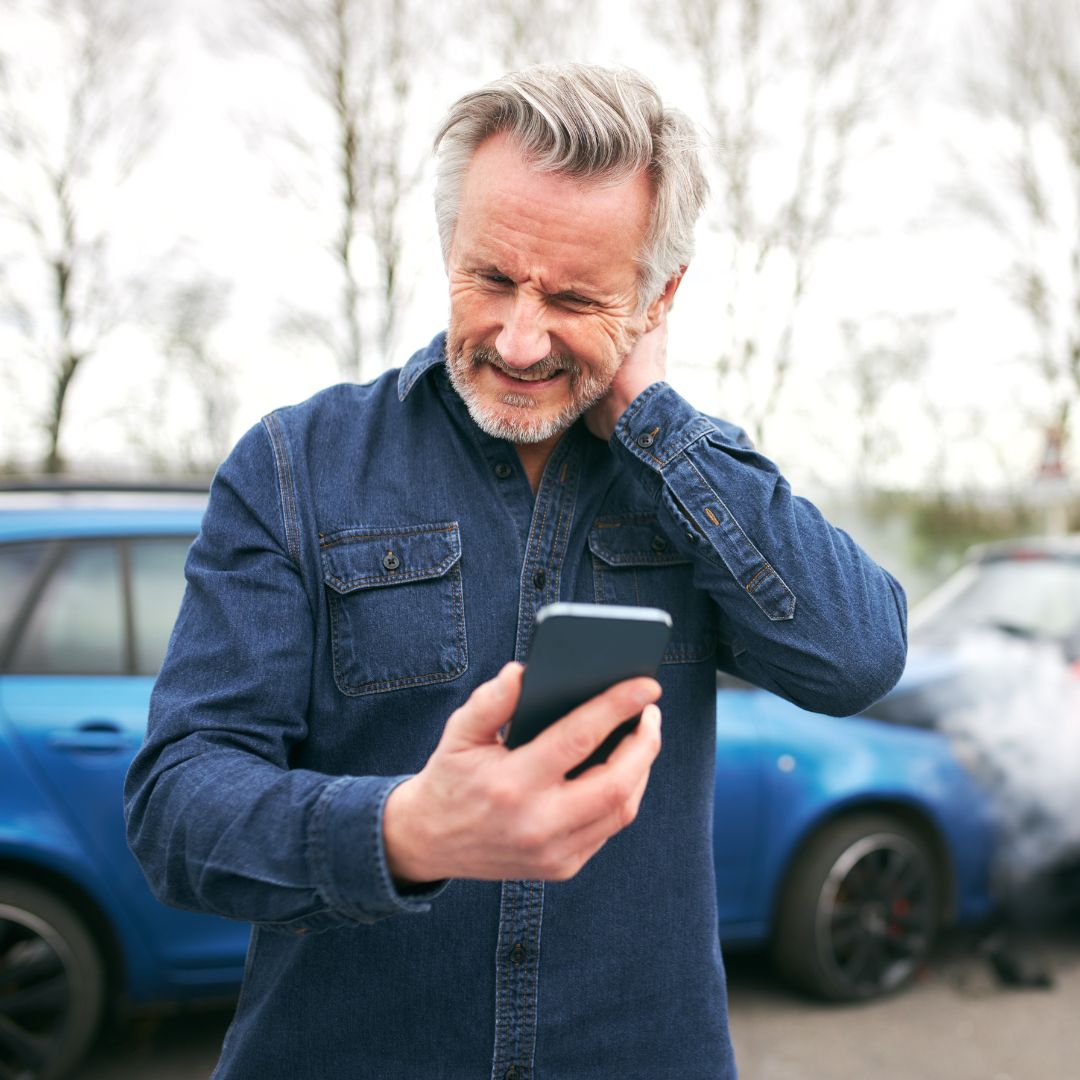 older man on phone after car accident
